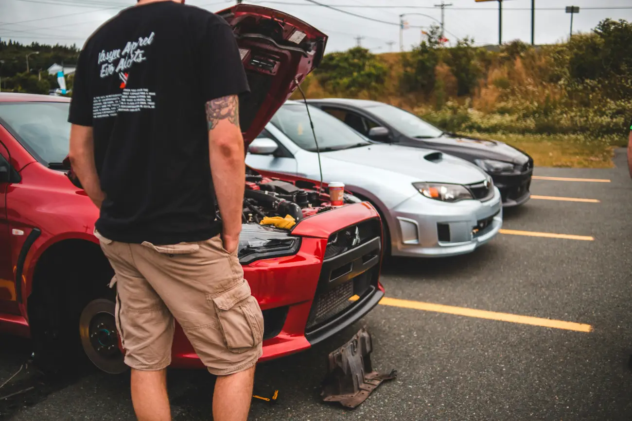 Car Enthusiast Tuning Engine at Outdoor Meet